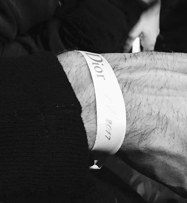 Close-up of a wrist wearing a Dior 2017 event access wristband