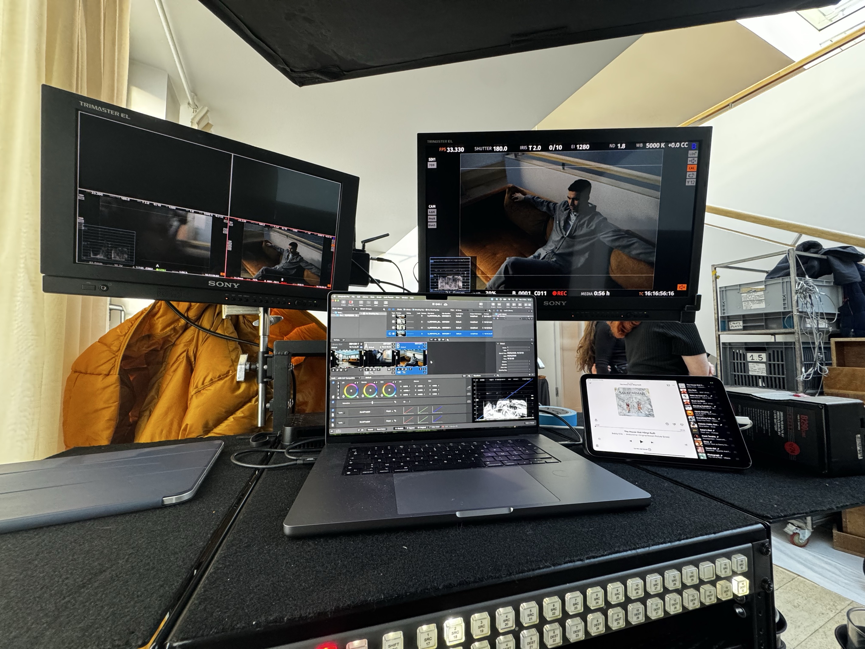 A D.I.T station with two Sony Trimaster monitors, a laptop running grading software and a switcher panel