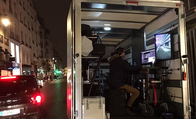 Night shoot in a Paris street, the D.I.T station set up in the back of a truck facing the monitors